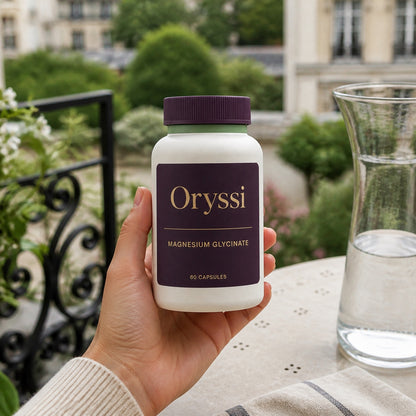 Hand holding Oryssi magnesium glycinate bottle on a balcony